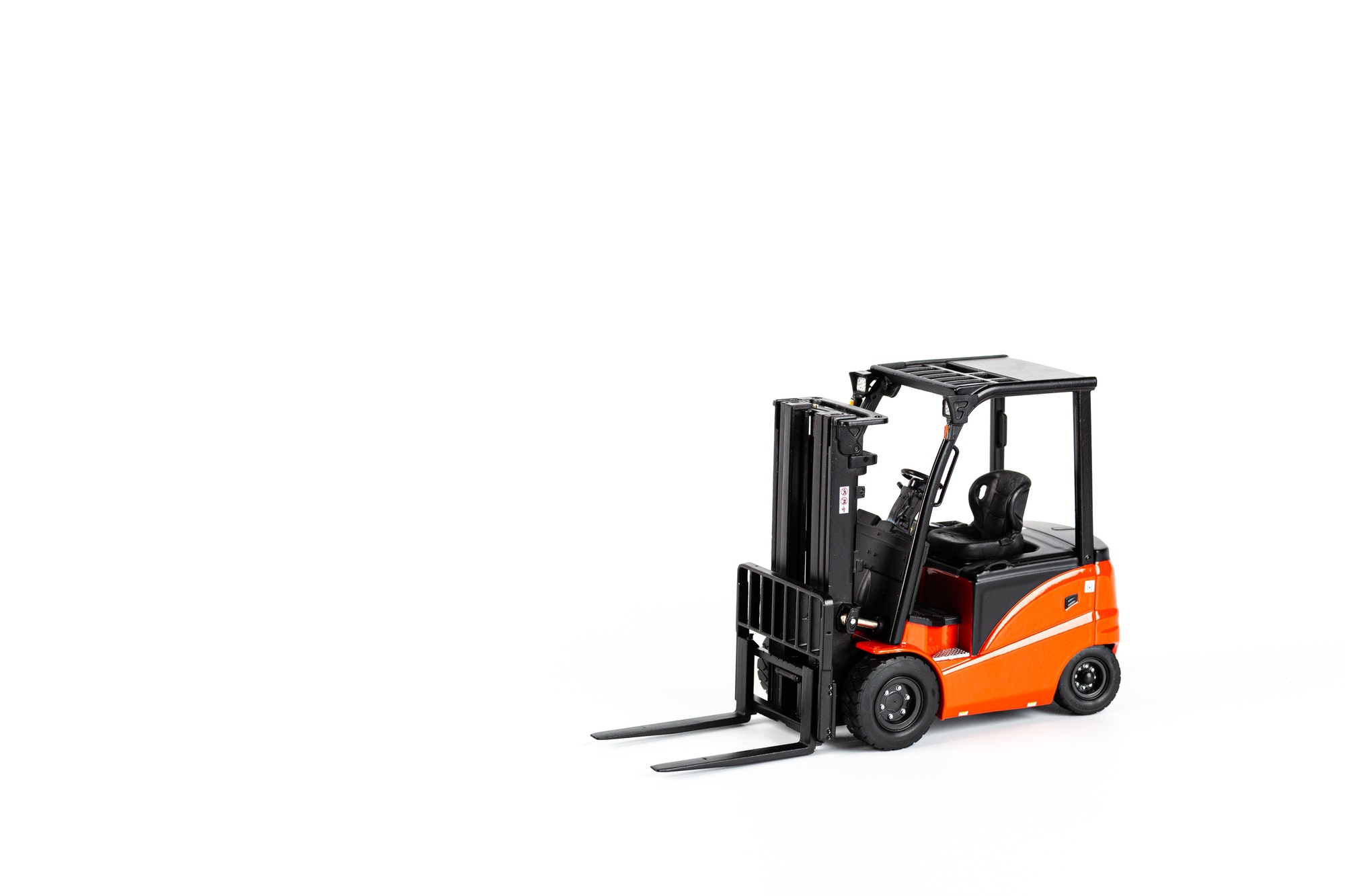 Miniature forklift toy on white background with copy space