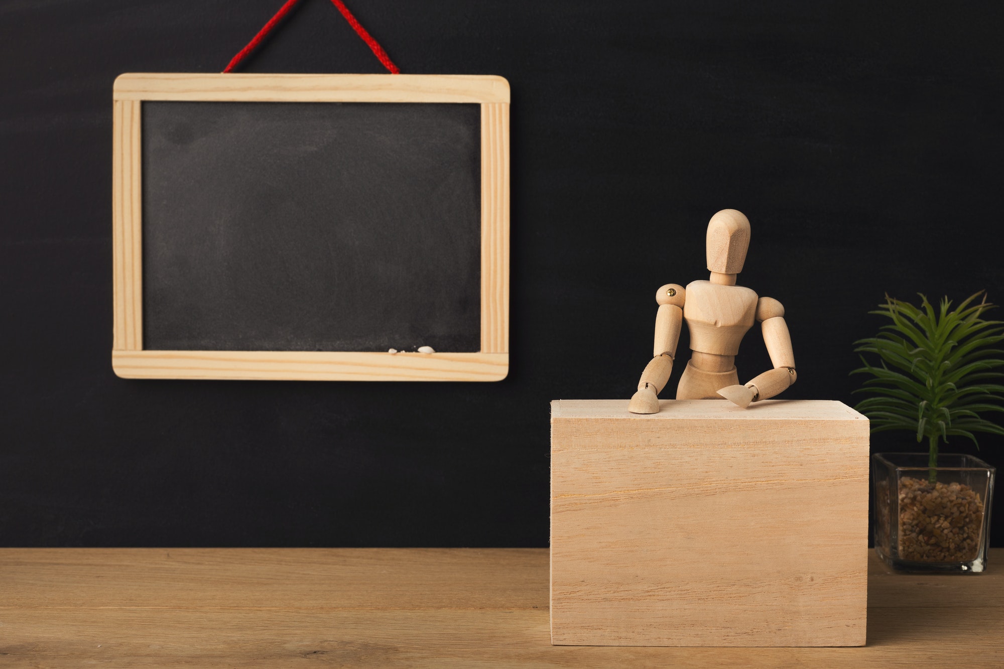 Wooden marionette sitting in classroom