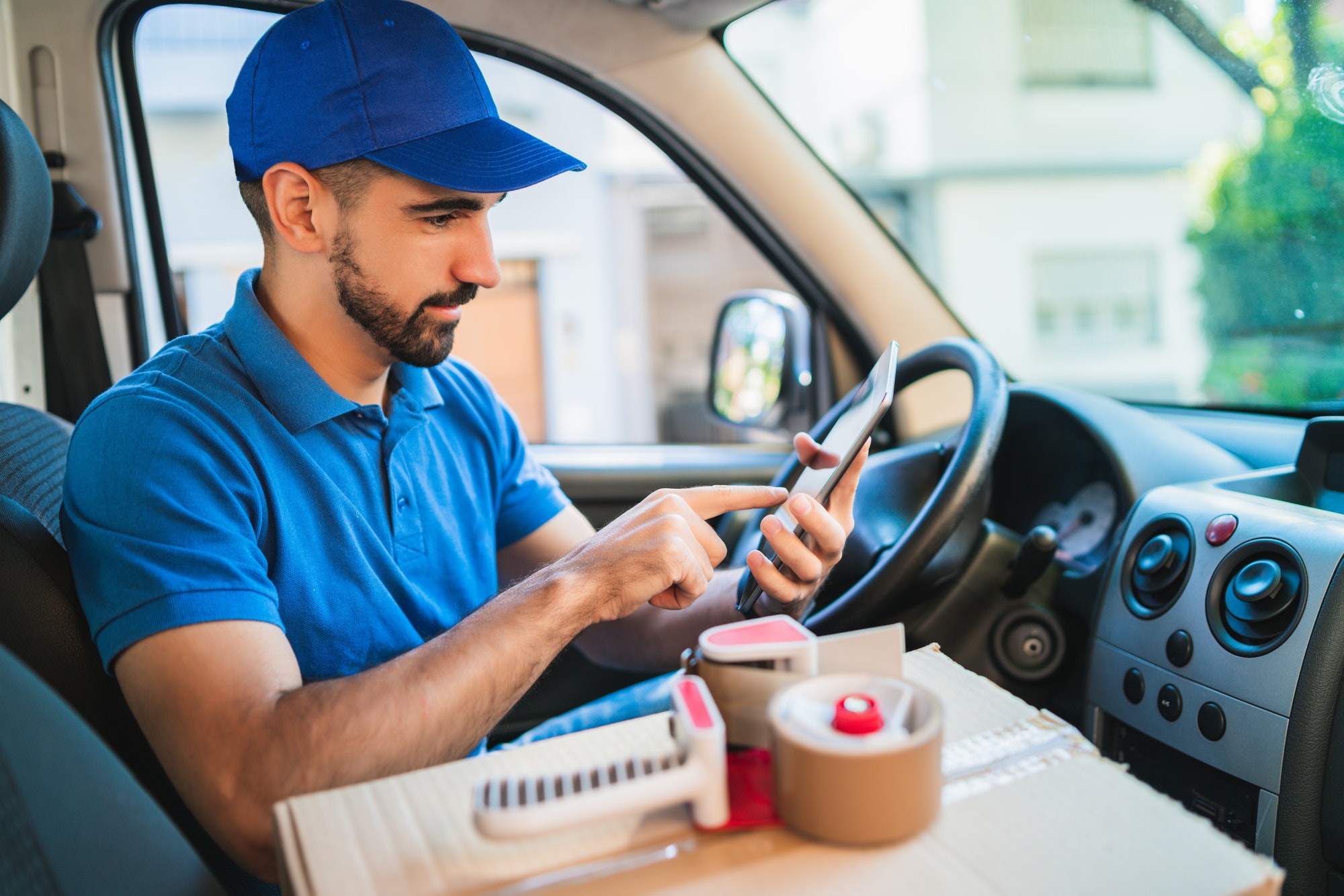 Delivery man driver using digital tablet.