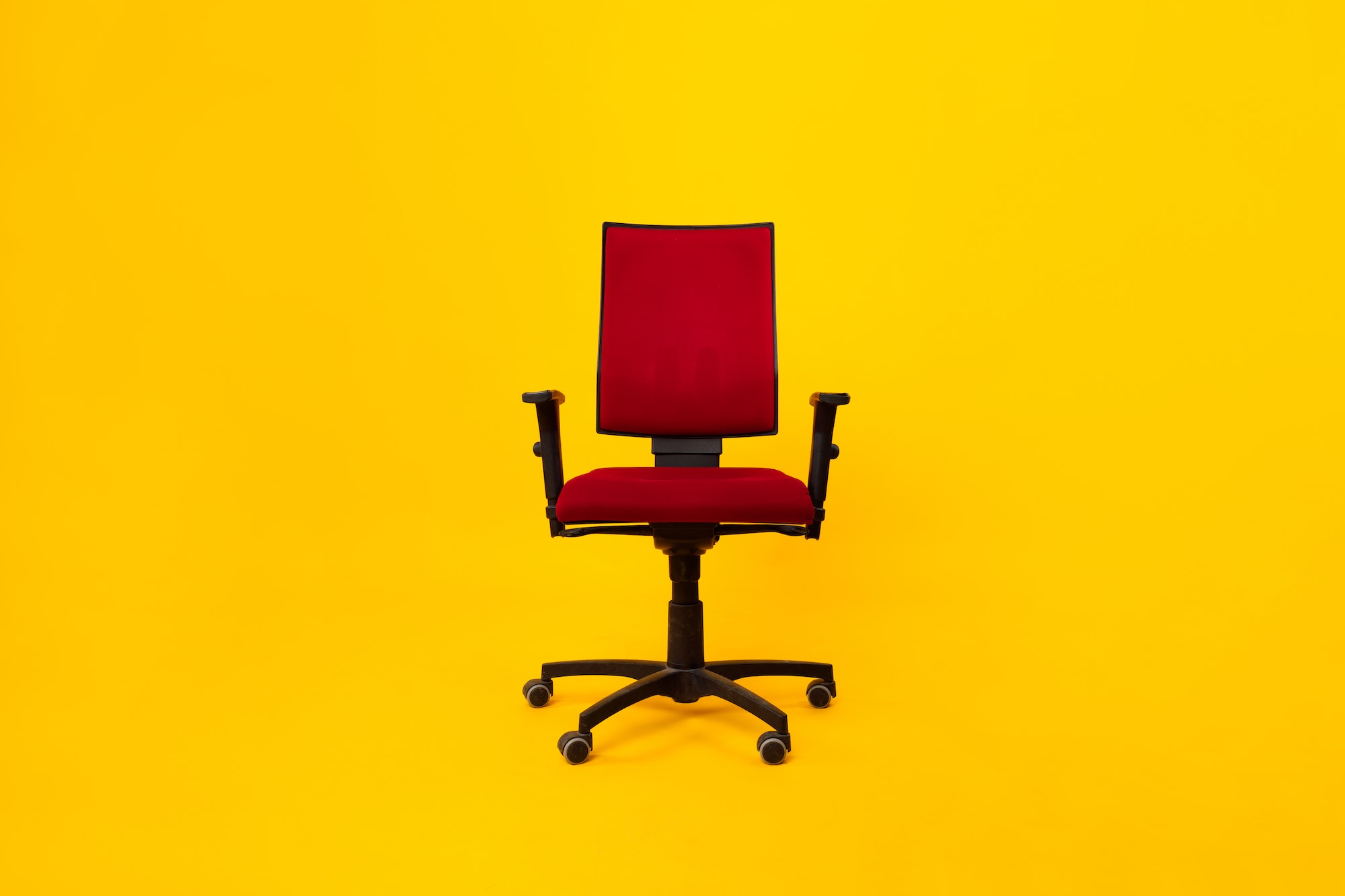Front View Of Red Adjustable Office Chair Over Yellow Background