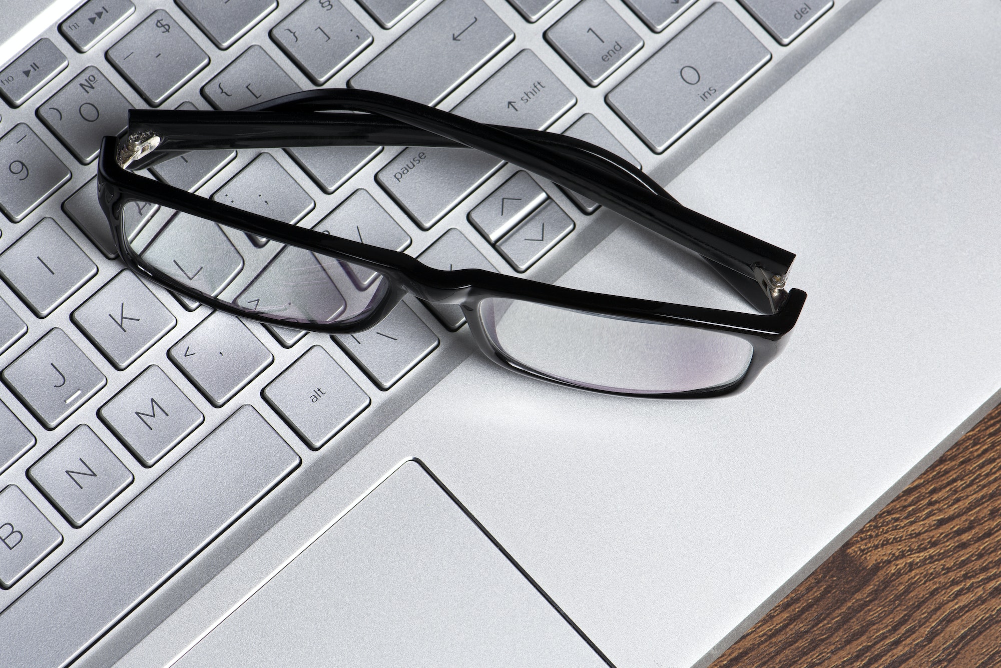Black glasses on computer keyboard
