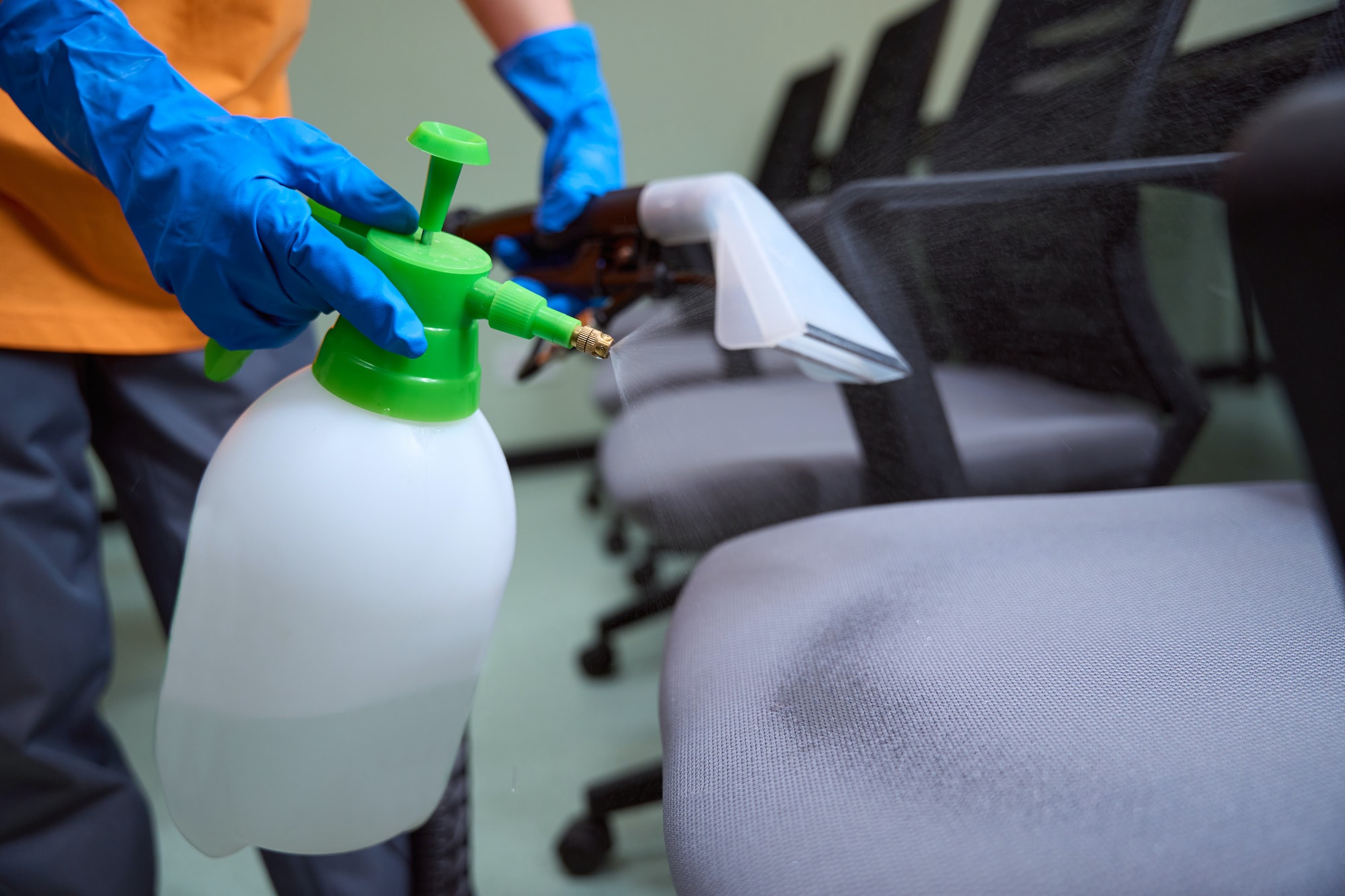 Hard-working cleaner using chemicals to disinfect the chairs