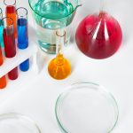 Chemical laboratory glassware with various colored liquids on table