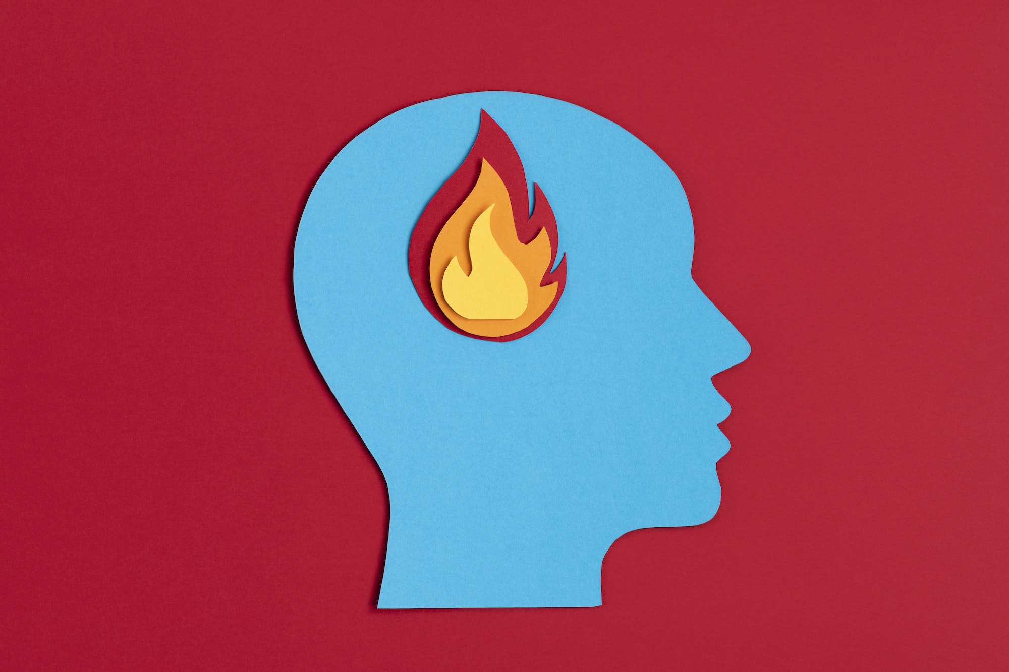 Papercut head with fire inside. Mental health problems, burnout, psychology, stress, mental illness