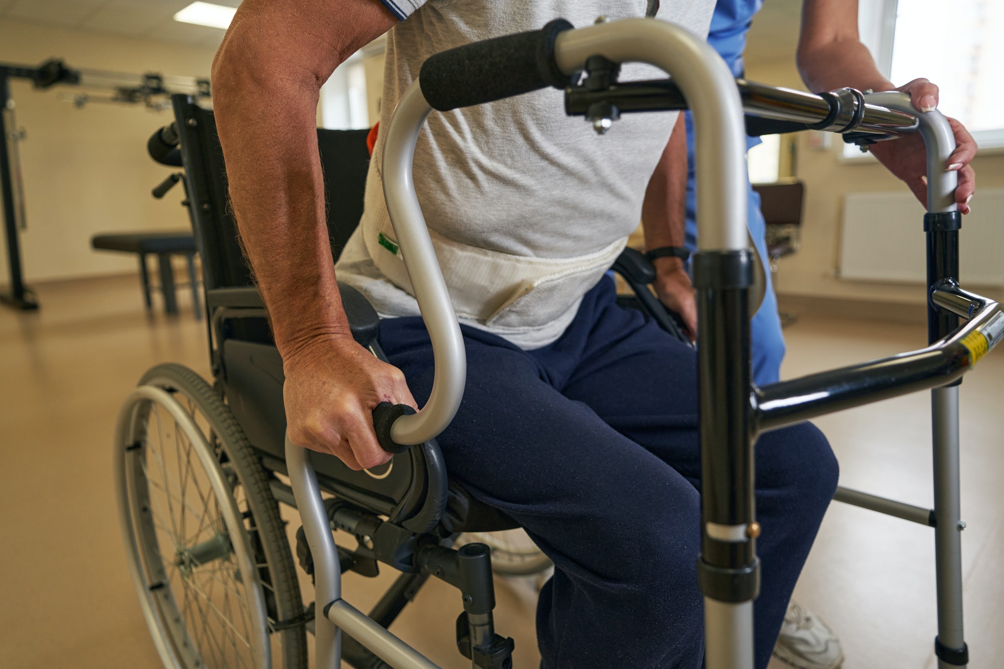 Stroke patient standing up with walking frame in hospital