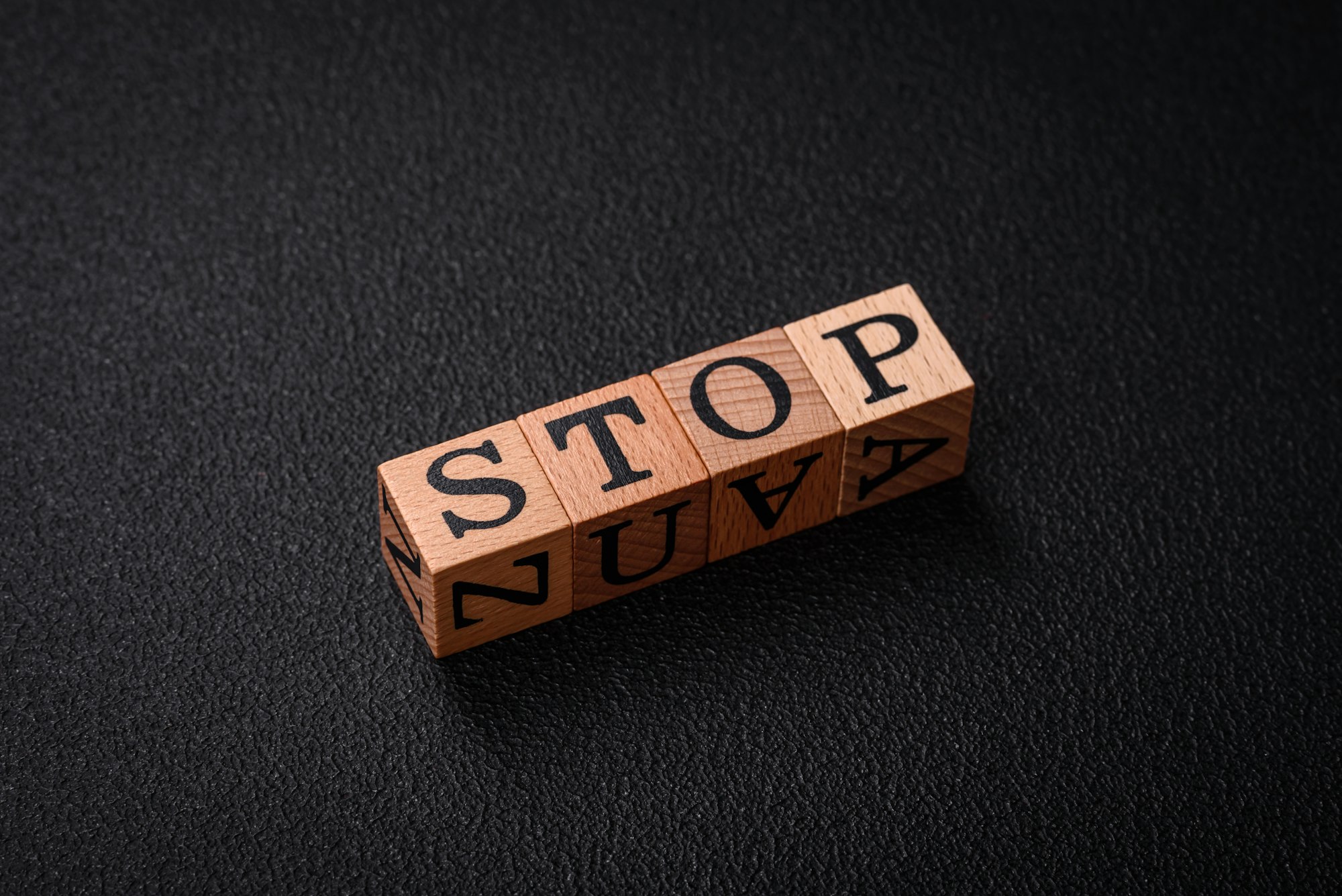 The inscription stop on wooden cubes on a dark concrete background