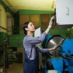 Female worker controlling the work of machine