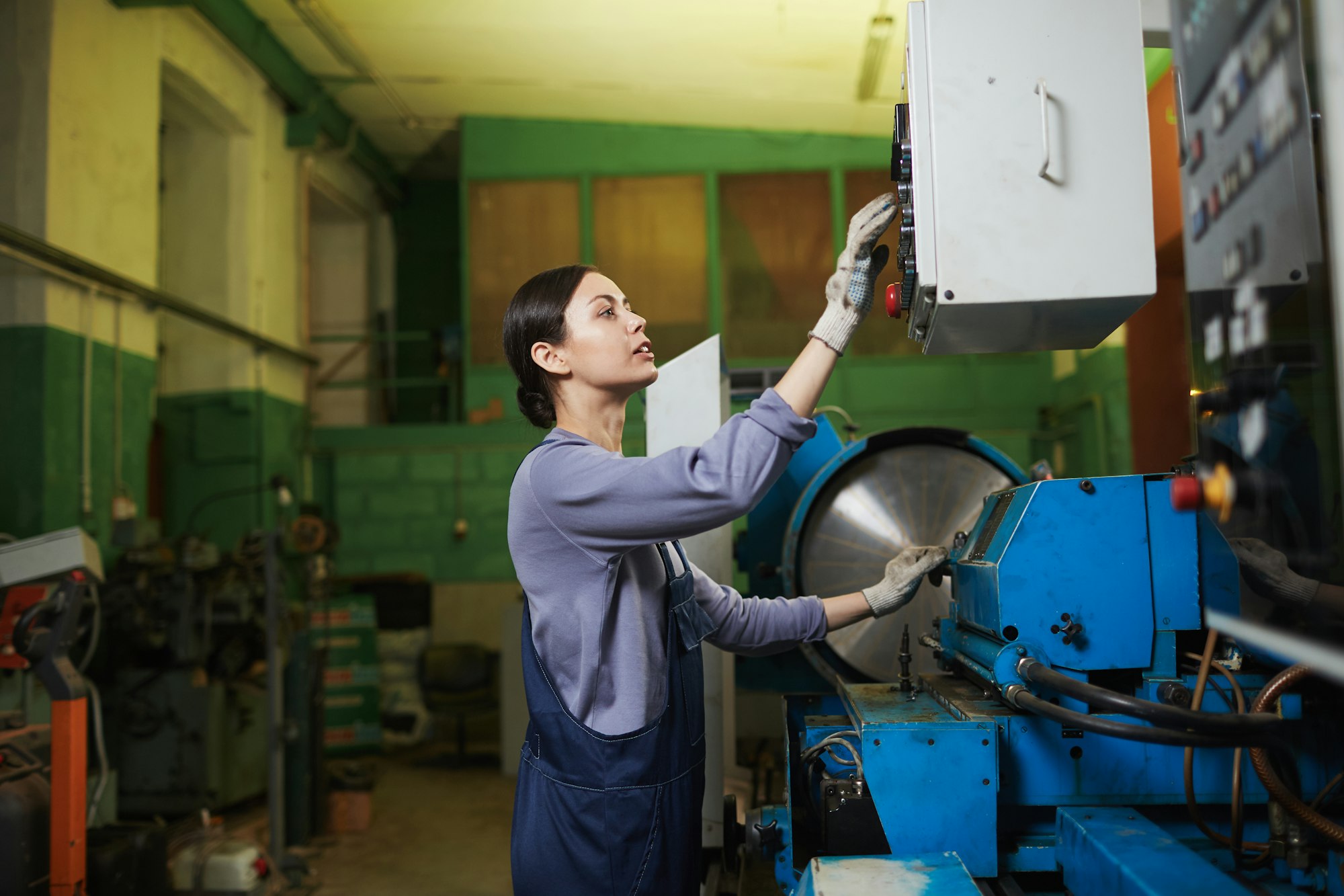 Female worker controlling the work of machine