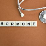 stethoscope and alphabet letters with the word hormone. the concept of women's disease.