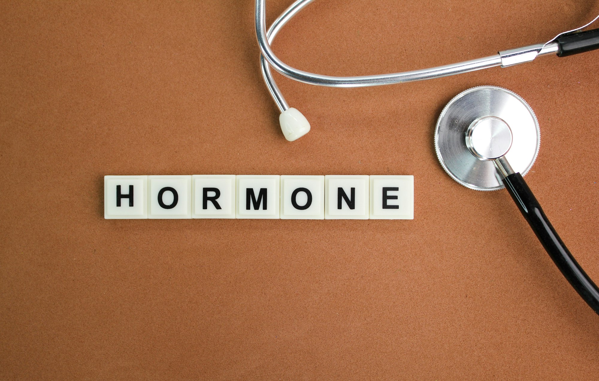 stethoscope and alphabet letters with the word hormone. the concept of women's disease.