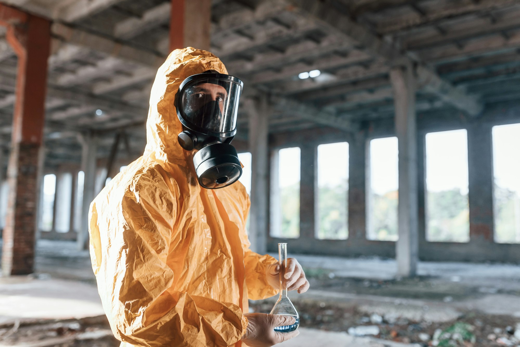 Portrait of man dressed in chemical protection suit that is in the ruins