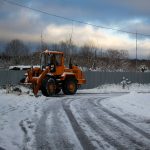 Трактор убирает снег.